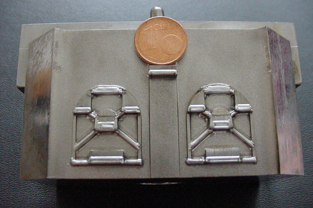 Kleines Stahl Bauteil mit filigranen und präzisen Laserschweißnähten, zum Größenvergleich liegt ein Cent-Stück auf dem Bauteil.