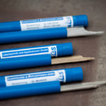 Laserschweißdraht Qualas® als gerichtete Stäbe in blauen Röhrchen.