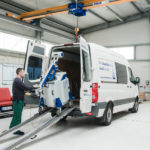 Techniker manövriert ein mobiles Laserschweißgerät (ALPHA LASER ALM 250) auf Rollen mithilfe einer Rampe aus einem Transporter zum Einsatzort.