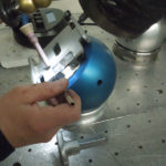 Blaue, hart eloxierte Aluminium‑Magnetspannkugel (Ø 140/160 mm) mit silbernem Sockel und T‑Griff‑Schlüssel. Die schaltbare Permanentmagnet‑Kugel zeigt eine flache Magnetspannfläche mit feinen konzentrischen Rillen – entworfen zur sicheren Fixierung und flexiblen Positionierung von Werkstücken an Laser‑ oder Polierarbeitsplätzen.