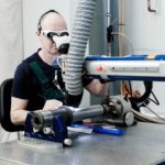 Laserschweißen am Bauteil, welches auf dem Rollenbock für Rohre gelagert ist.